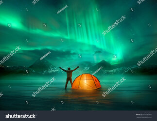 stock-photo-a-man-camping-in-wild-northern-mountains-with-an-illuminated-tent-viewing-a-specta...jpg